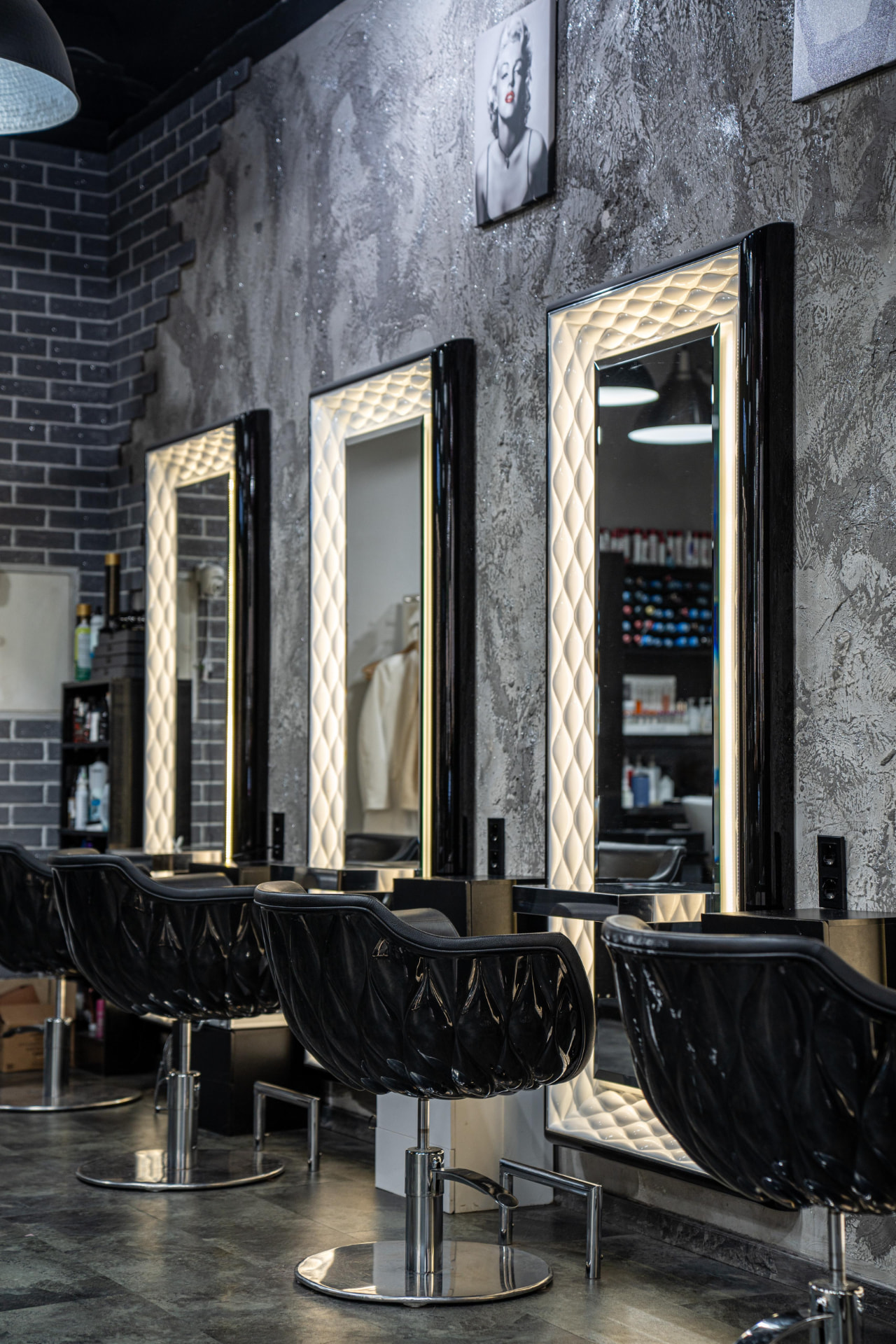 Beleuchtete Friseurspiegel mit schwarzen Styling-Sesseln